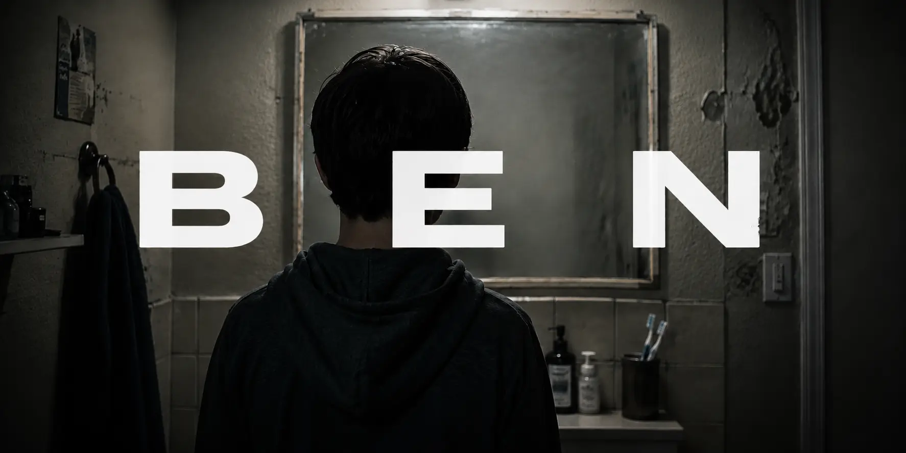 A boy seen from behind facing a dark bathroom mirror, the name BEN stamped across the image